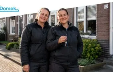Two middle-aged women working through an employment agency standing in front of a Dutch home with mortgage documents in the Netherlands